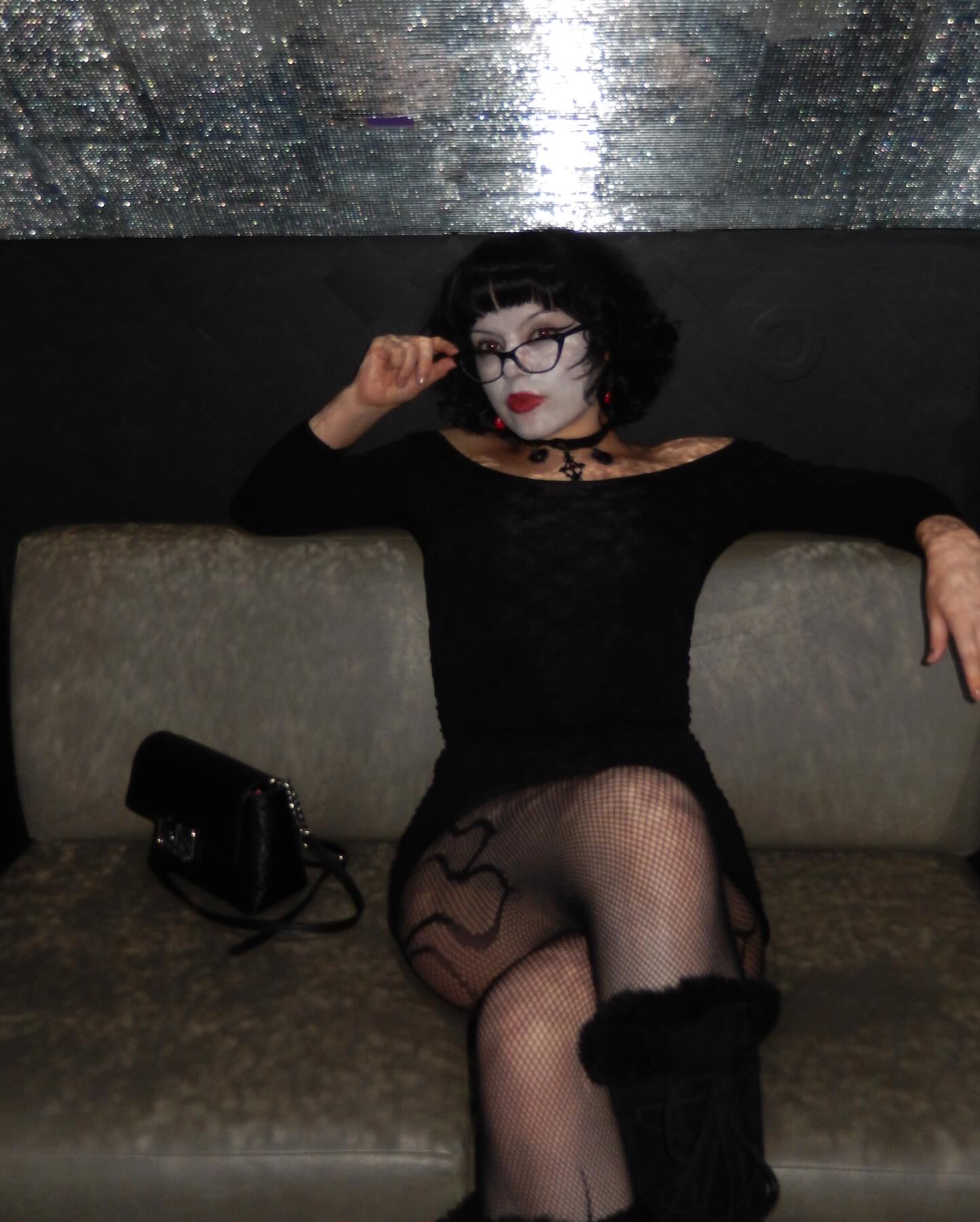 Aura sitting on a sofa in gothic glam style